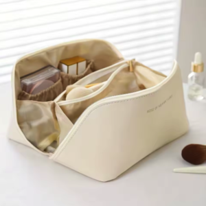 Bolsa organizadora para viaje con cremallera desplegable Bolsa organizadora para viaje con cremallera abierta mostrando sus compartimentos para cosméticos.