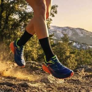 Ofertas en zapatillas de running con Bikila Corredor disfrutando de ofertas en zapatillas de running profesionales en un sendero de montaña.